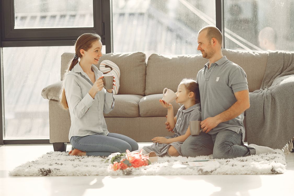 Famiglia che ride insieme sul divano mentre ricorda le vacanze