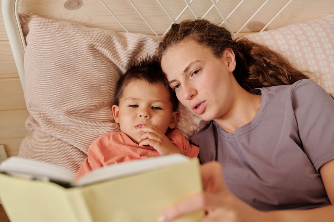 Bambino che ascolta la storia della buonanotte in una cameretta accogliente